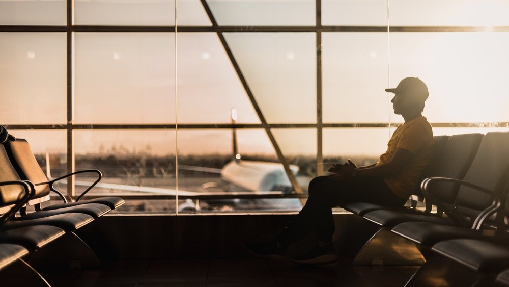 a man sitting at the airport early in the morning