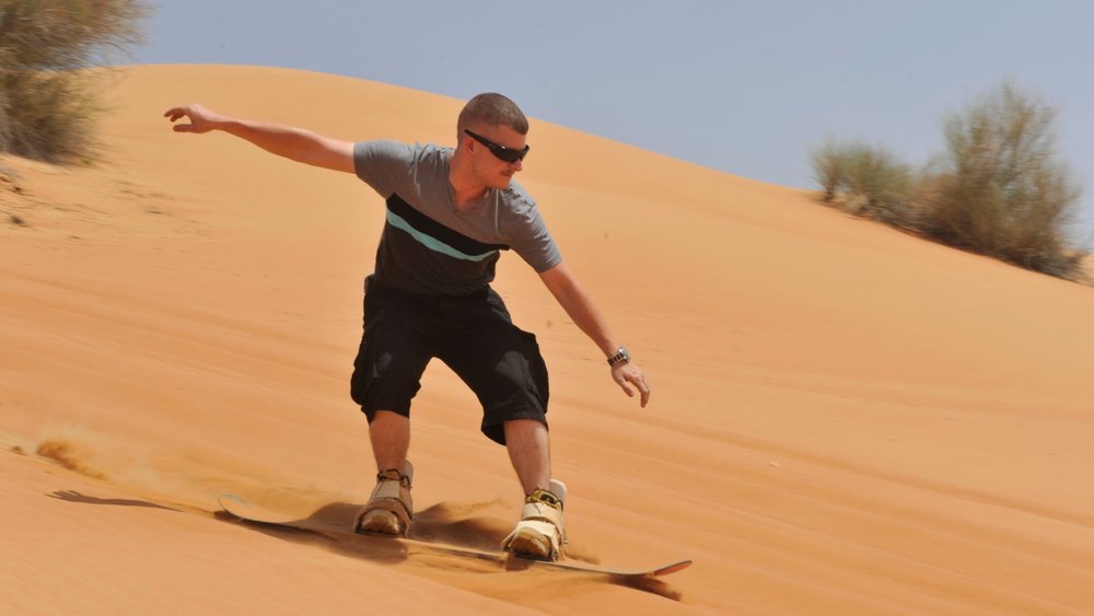 a man sandboarding in the desert
