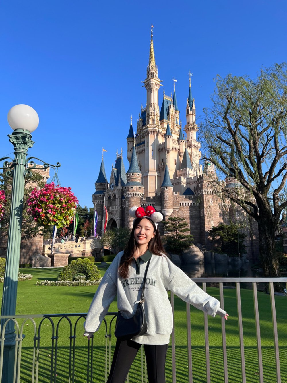 一個女孩在東京迪士尼城堡前拍照
