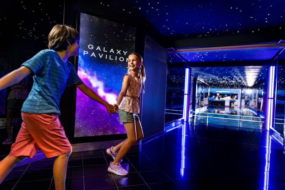 Kids holding hands by the Galaxy Pavilion signage