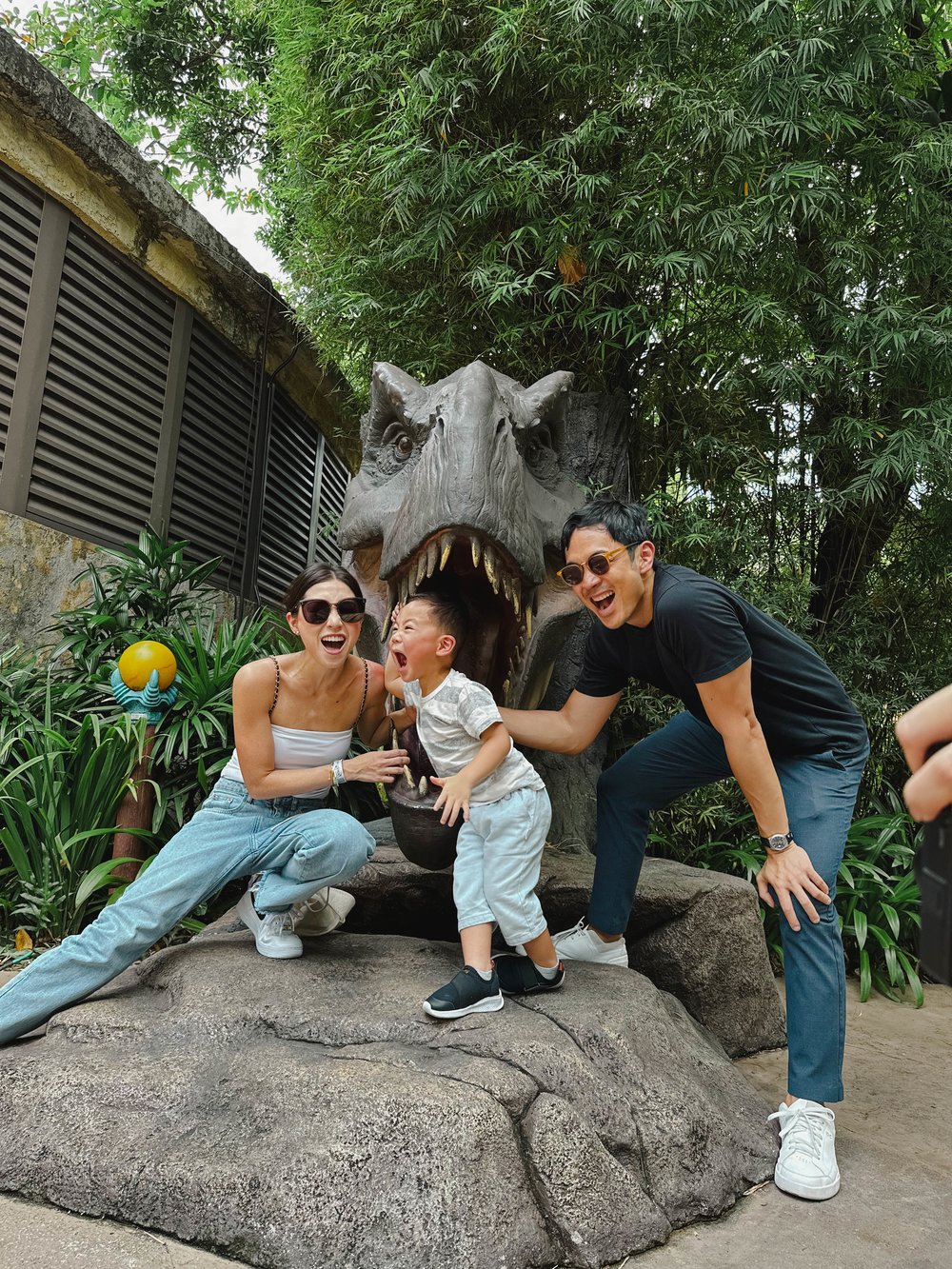 kryz uy and slater young with son and dinosaur statue