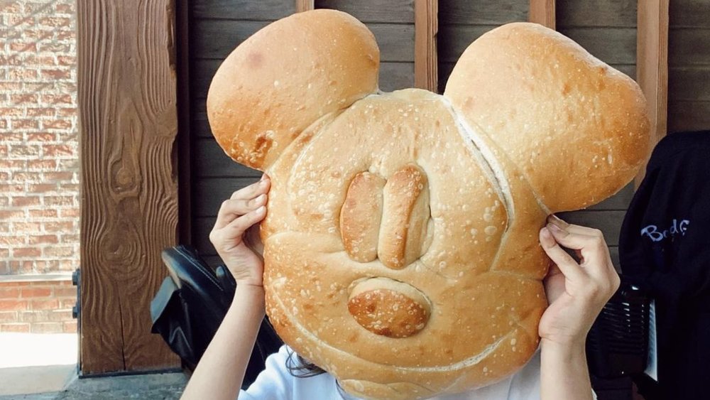 Mickey Mouse sourdough bread is a delightful and iconic treat at Disneyland, featuring the beloved character's shape and a delicious sourdough flavor that captures the essence of the park. Photo credit to @janetlledesma on Instagram.