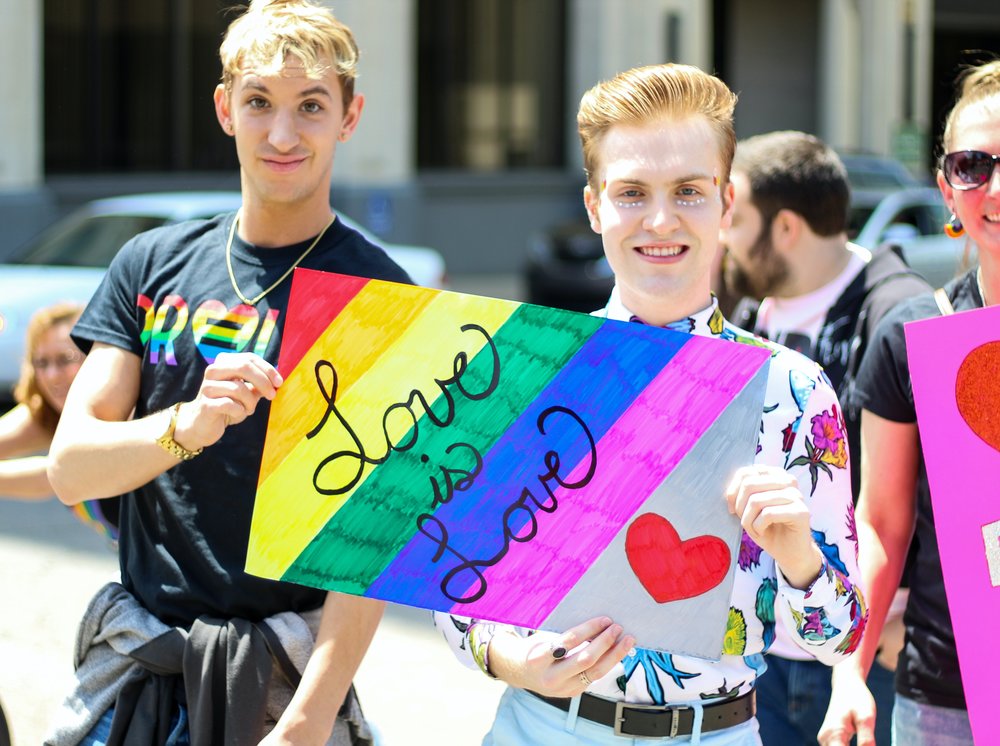 Gay couple holding a pride banner 