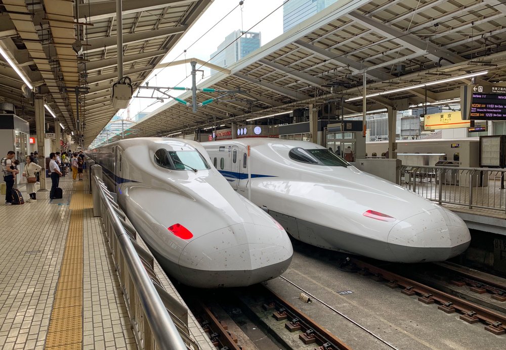 Two white bullet trains at a train station