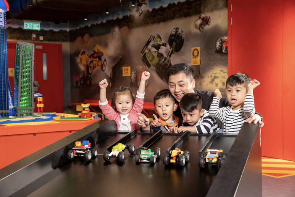 kids and adult watching lego race track