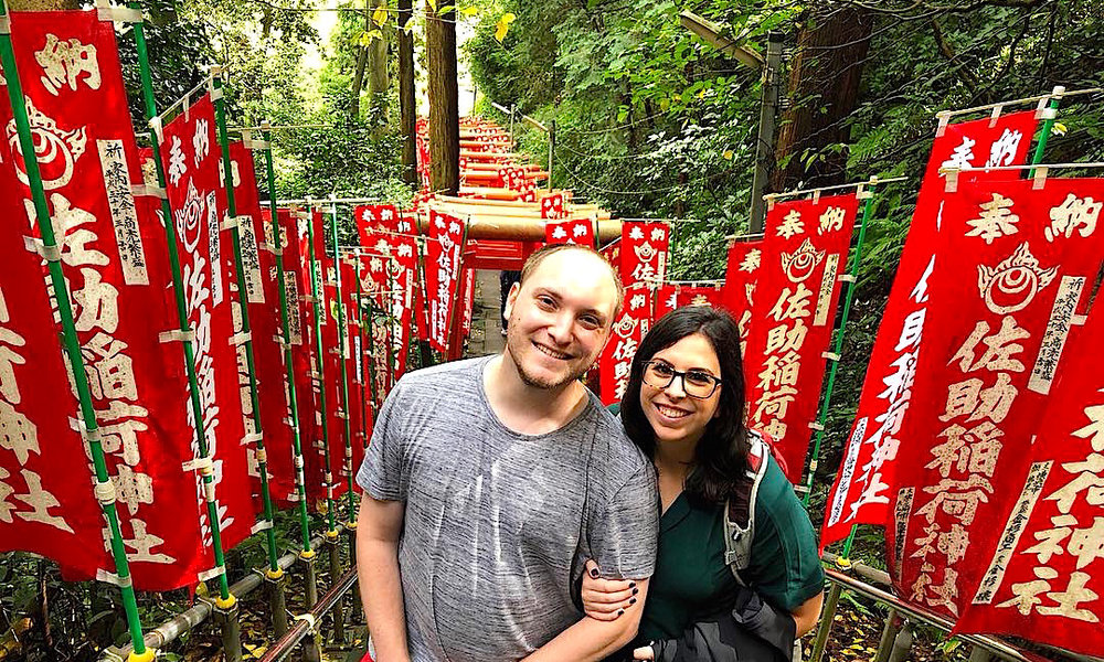 Man and woman smiling surrounded by red banners