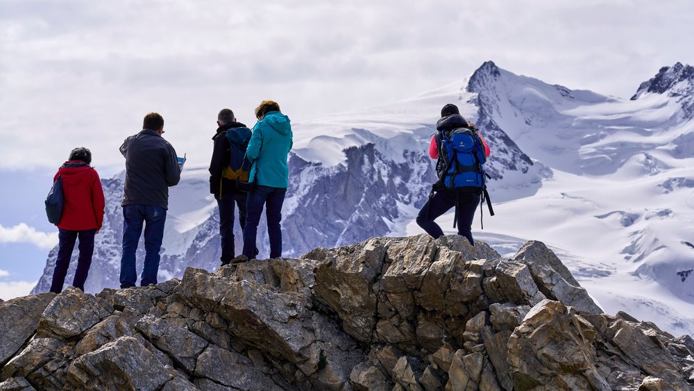 People at the Gornergrat ridge looking at the immense glacier.