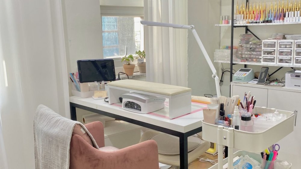 a nail salon set up with chair, lights, and a nail heating machine