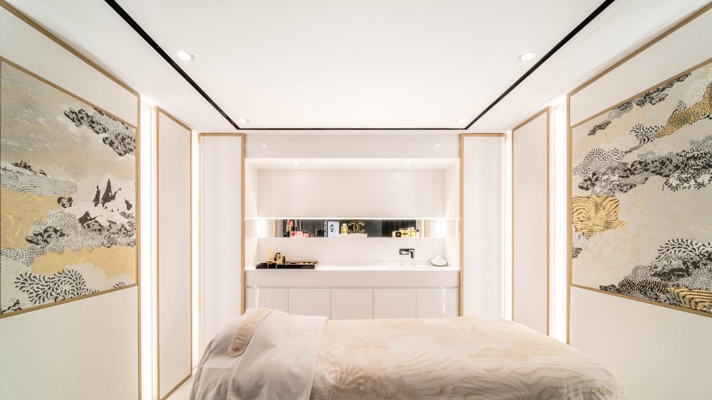 a room in a spa with a massage bed, warm light, and beautiful paintings on both sides