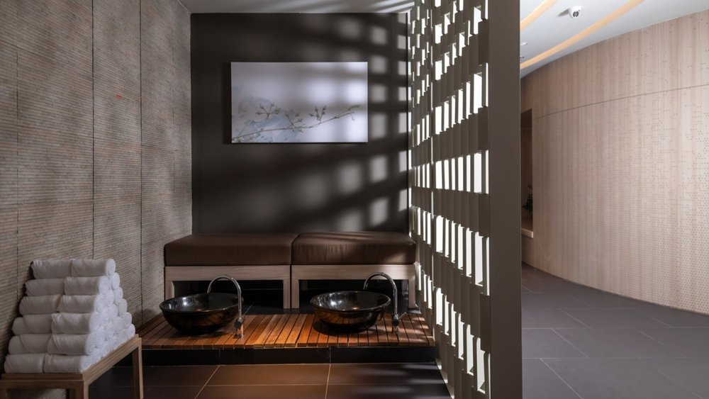 an area in the spa where there are two bowls elevated by a bench for a foot wash