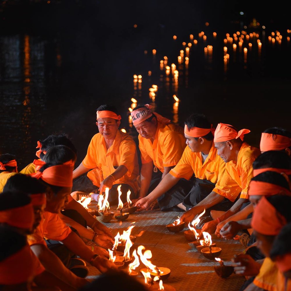 People sailing away lanterns in the river