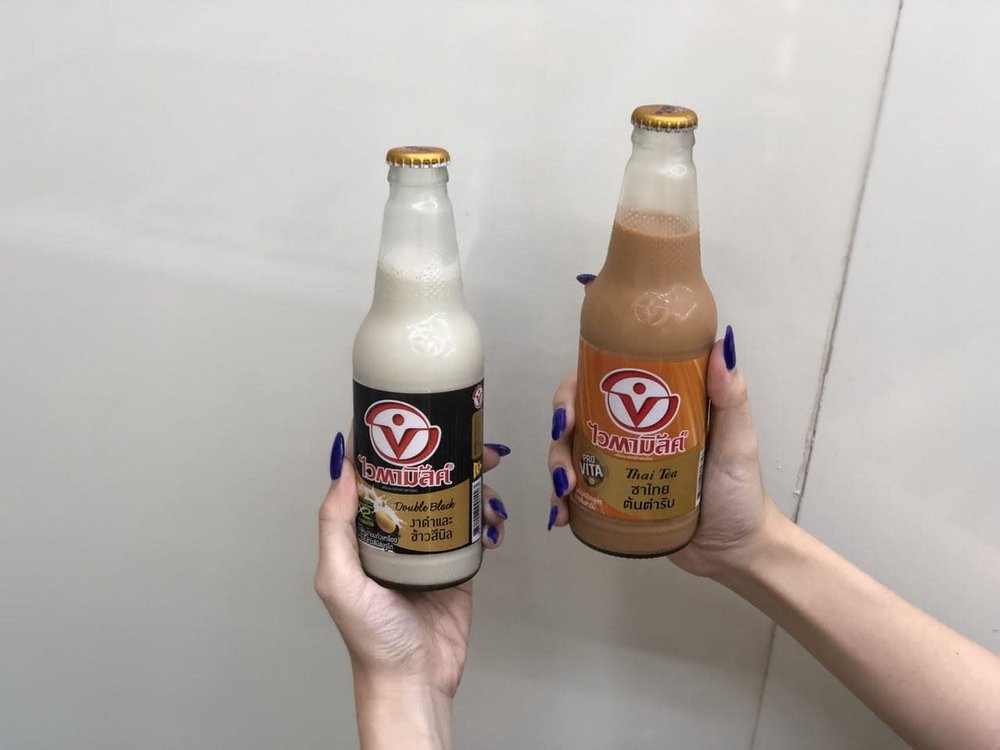 People holding bottles of Thai milk tea soy milk