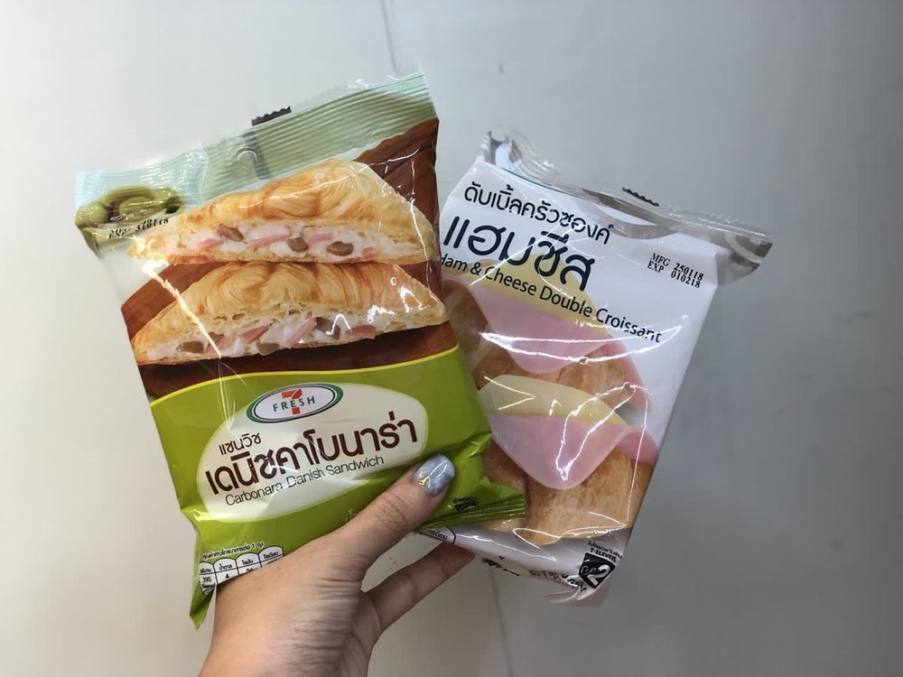 Person holding two packs of croissant sandwiches