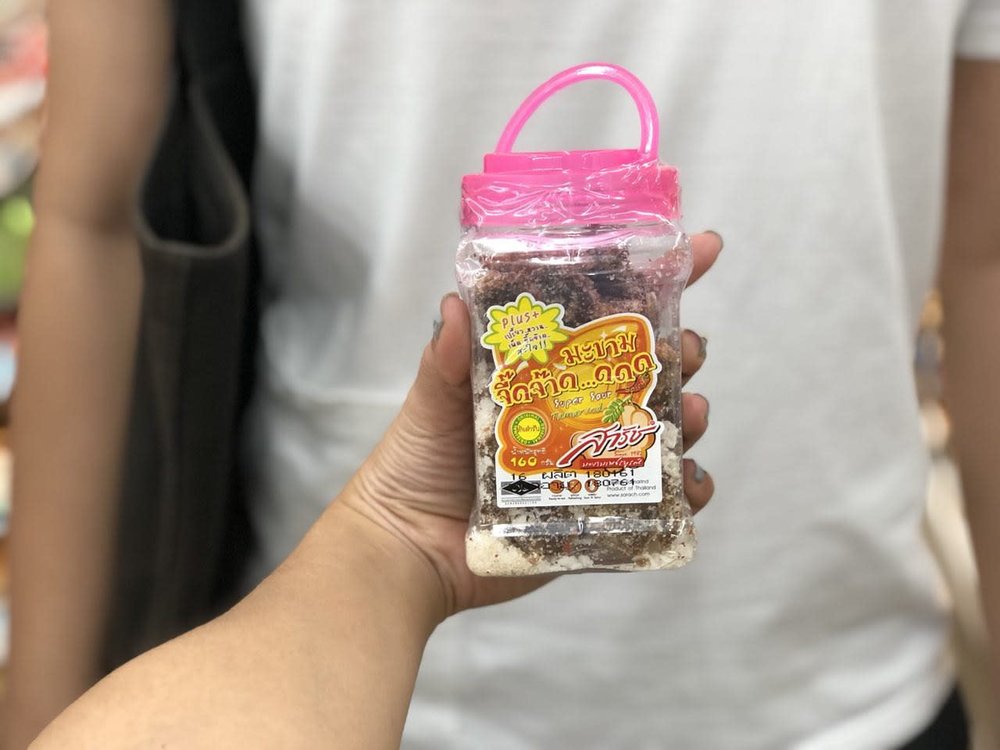 Person holding a container of a preserved fruit snack