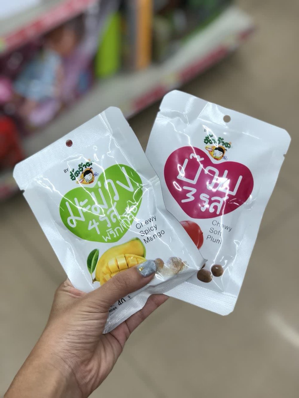Person holding two packs of preserved fruit snacks
