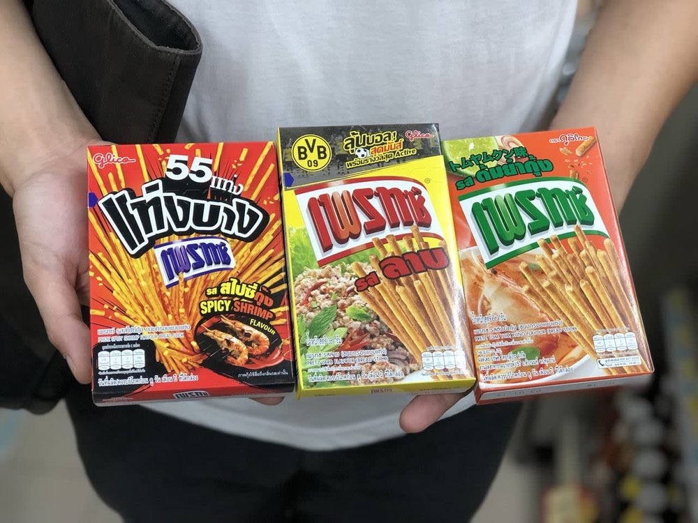 Person holding three boxes of spicy Pretz sticks