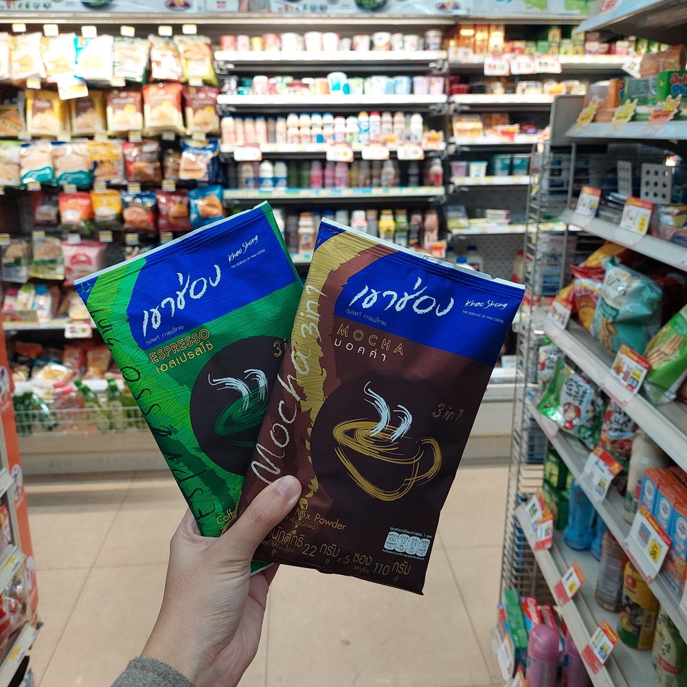 Person holding two packs of instant Thai coffee
