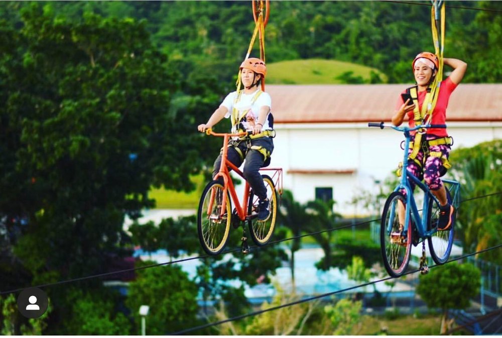2 girls riding a sky bicycle