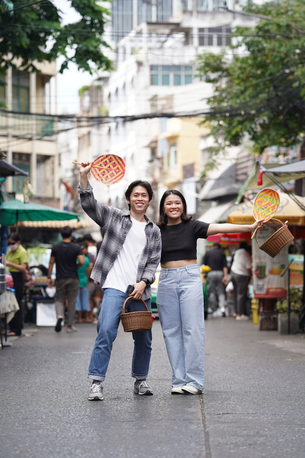 Man and woman holding baskets and fans