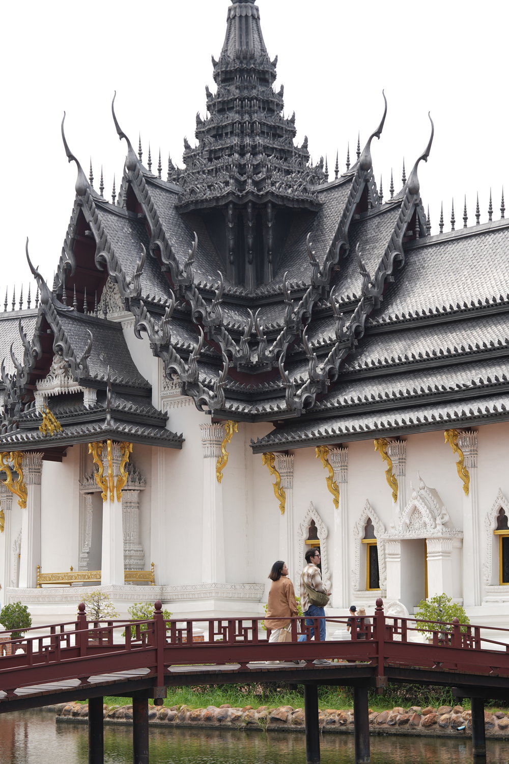 Man and woman crossing a red bridge