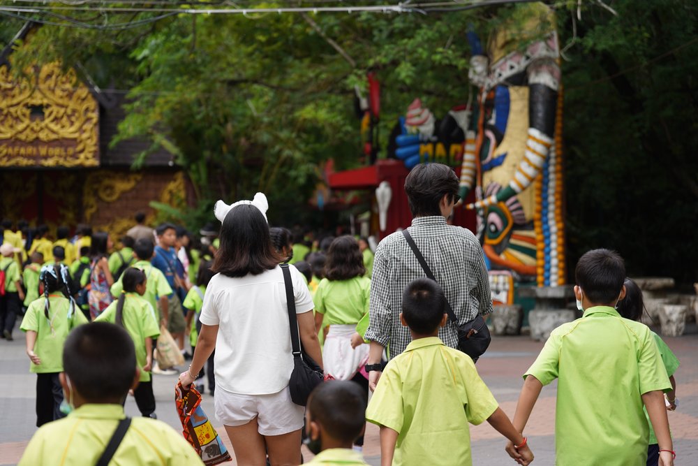 Man and woman walking with kids in green