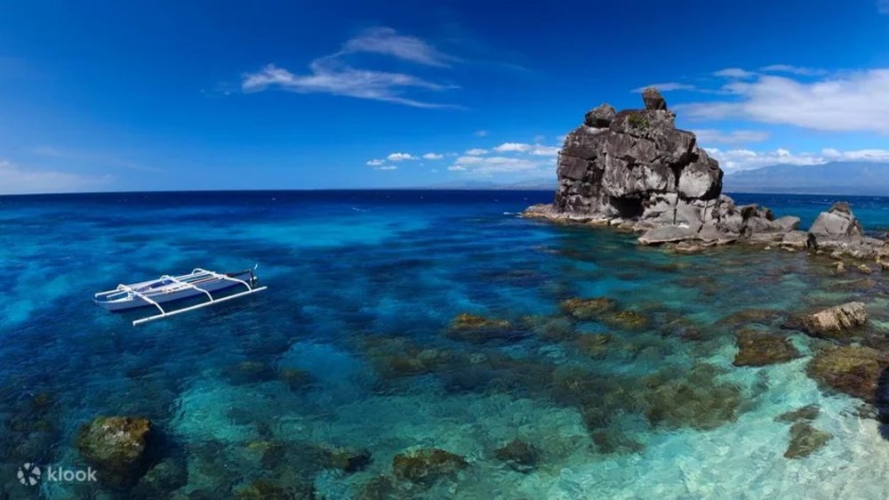 A boat and a stone island in the sea