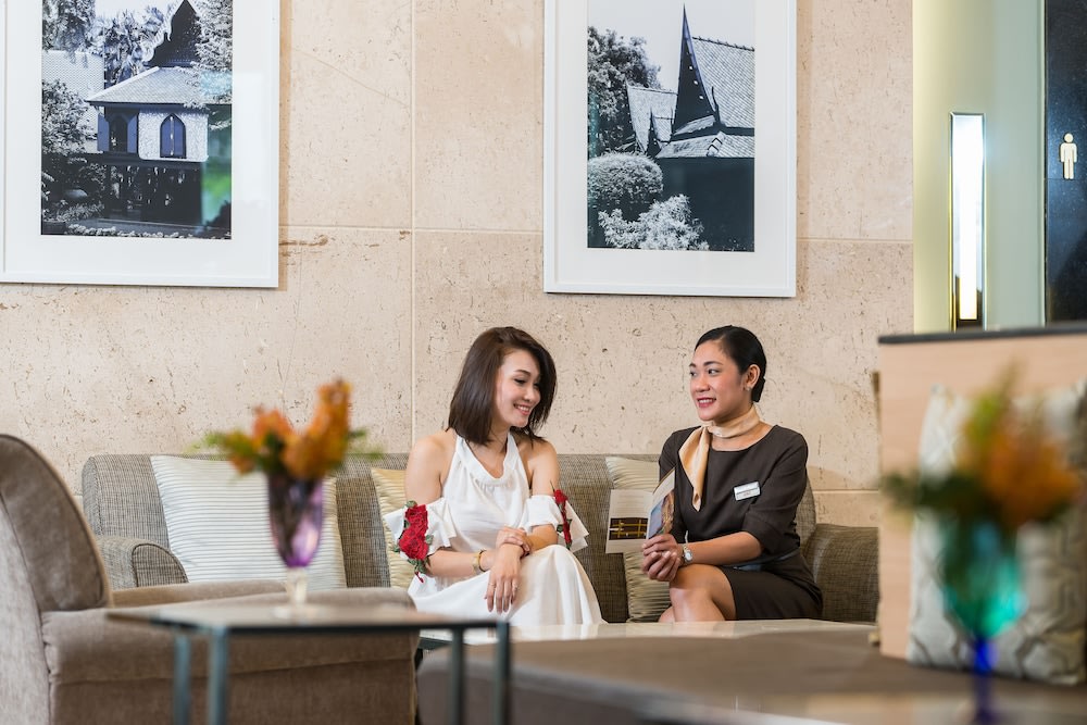 Staff and woman talking at the hotel lobby