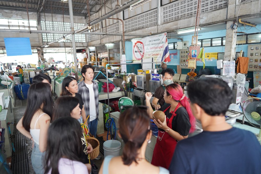 People listening to a chef at a market