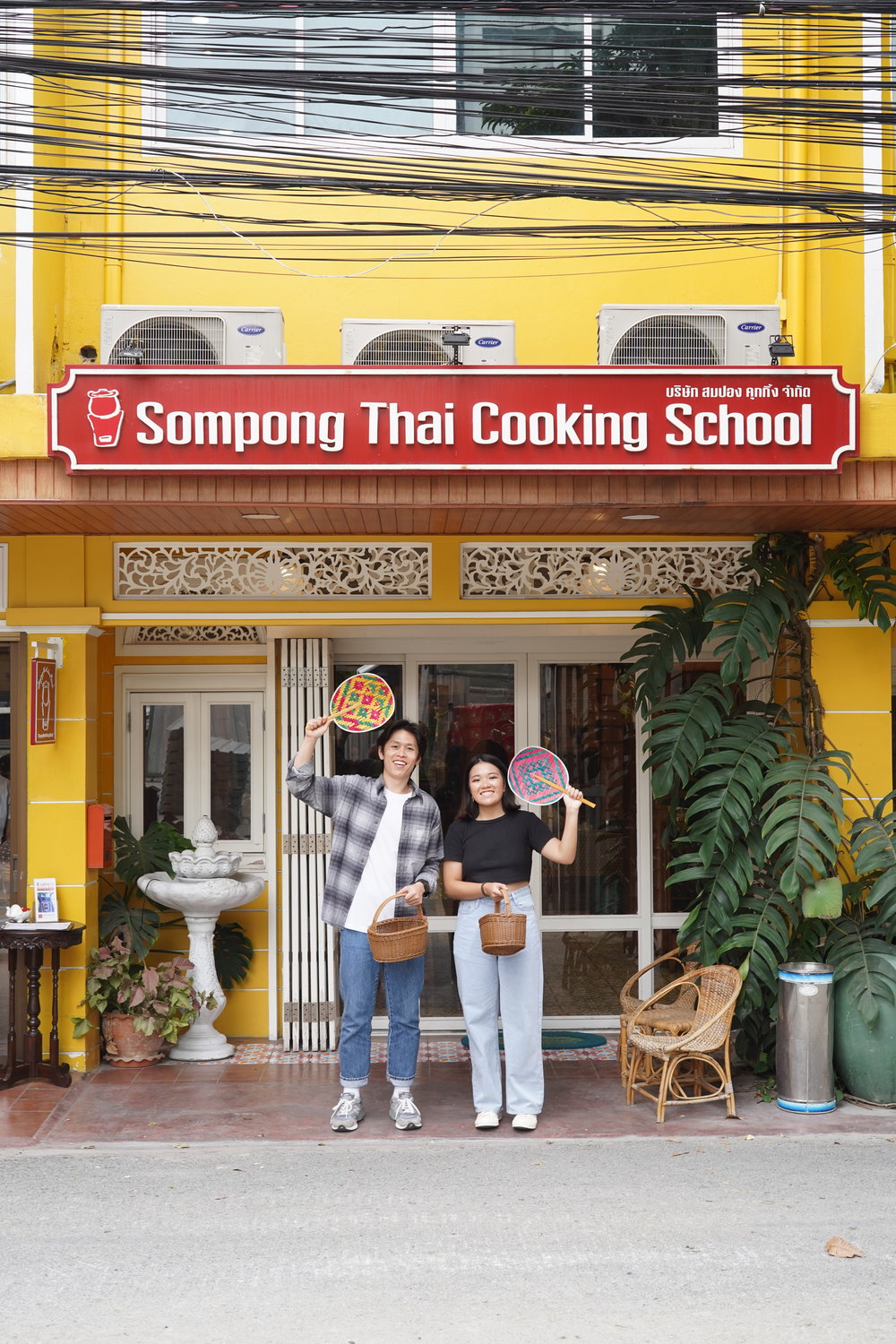 Man and woman happily holding fans and baskets