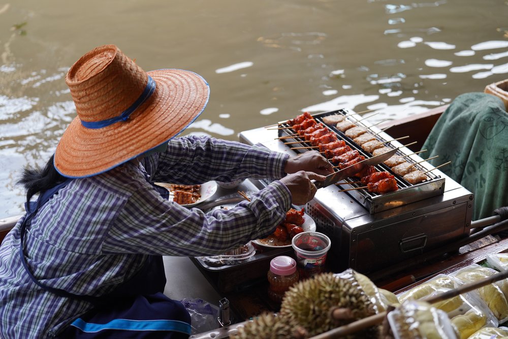 Woman selling grilled skewers
