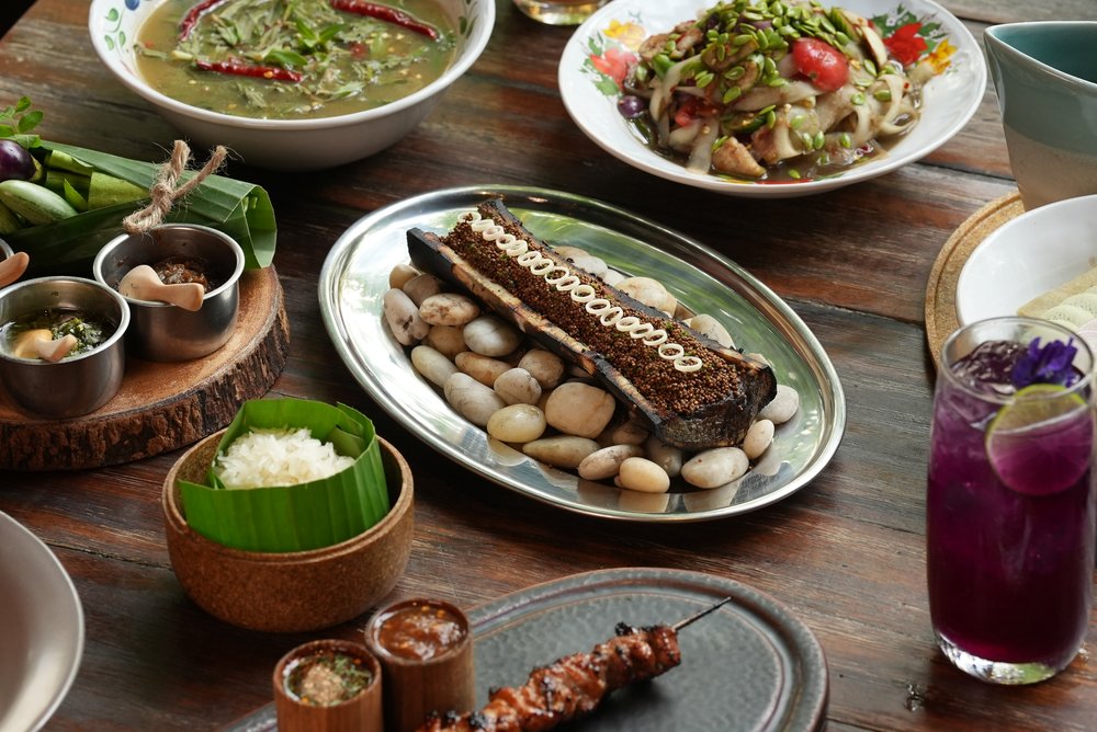 Different Thai dishes and a drink set up on a table
