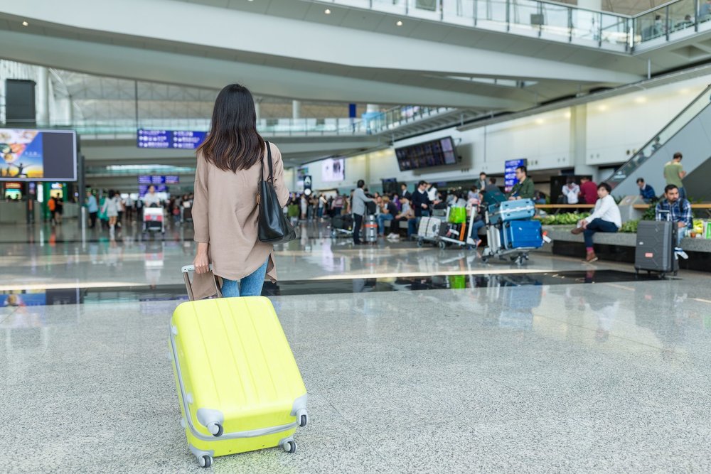 Woman Walking with Luggage in Hong Kong International Airport