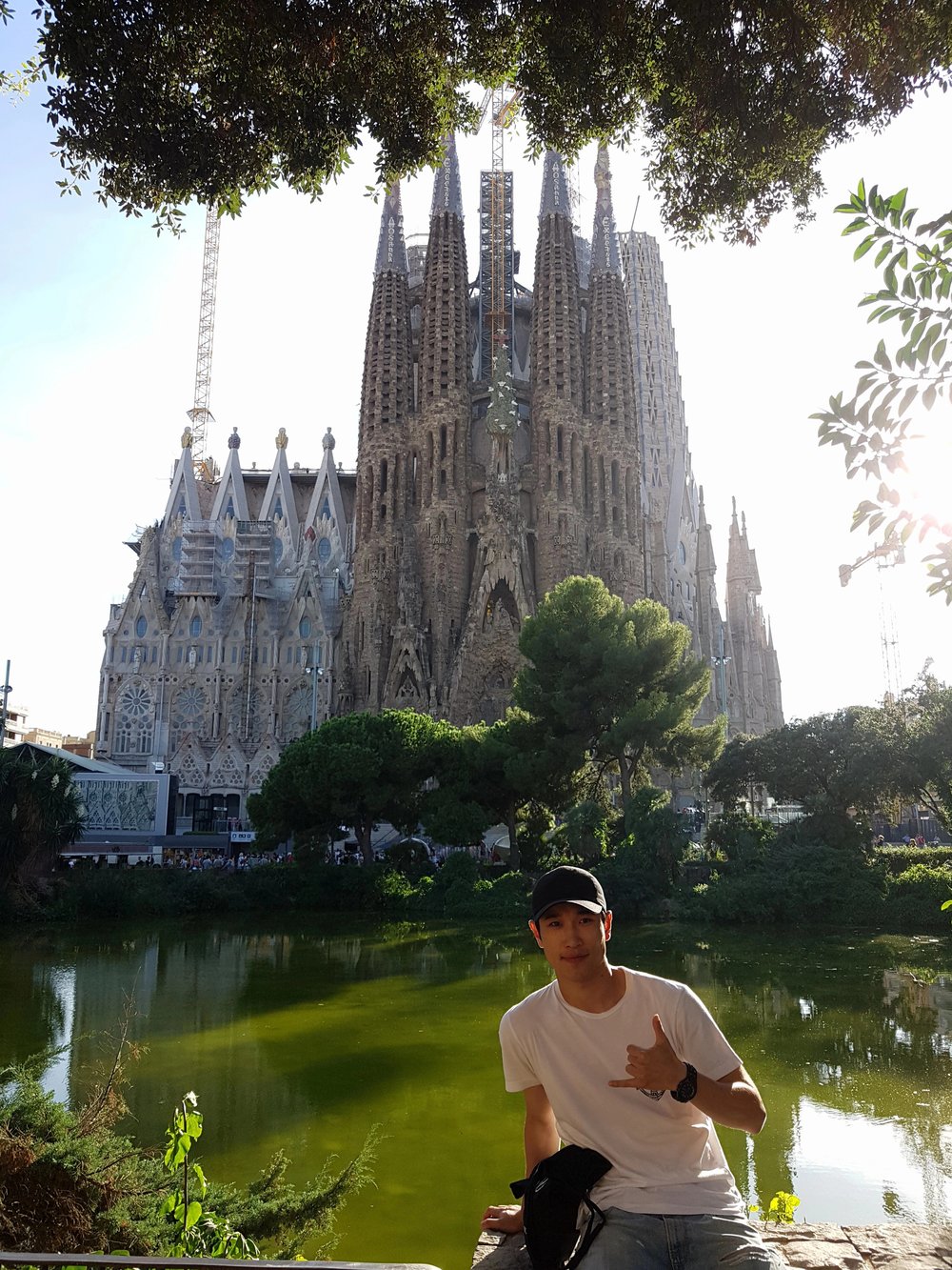 man posing with la sagrada familia in the background