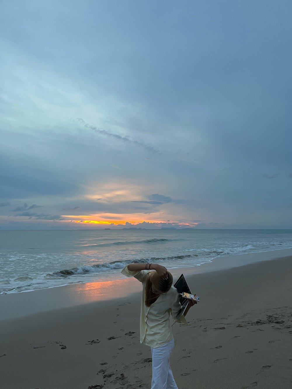 woman posing by the beach during sunset