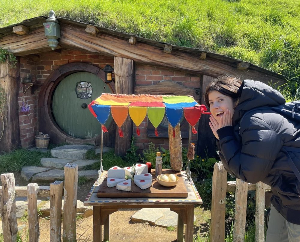 woman posing with pros in the hobbiton set in new zealand