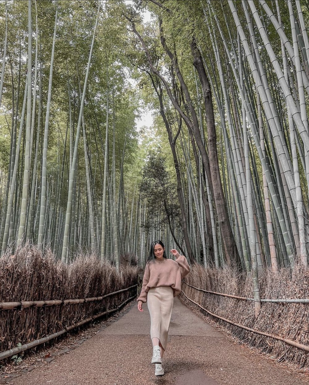 Woman posing while walking in the middle of bamboo trees
