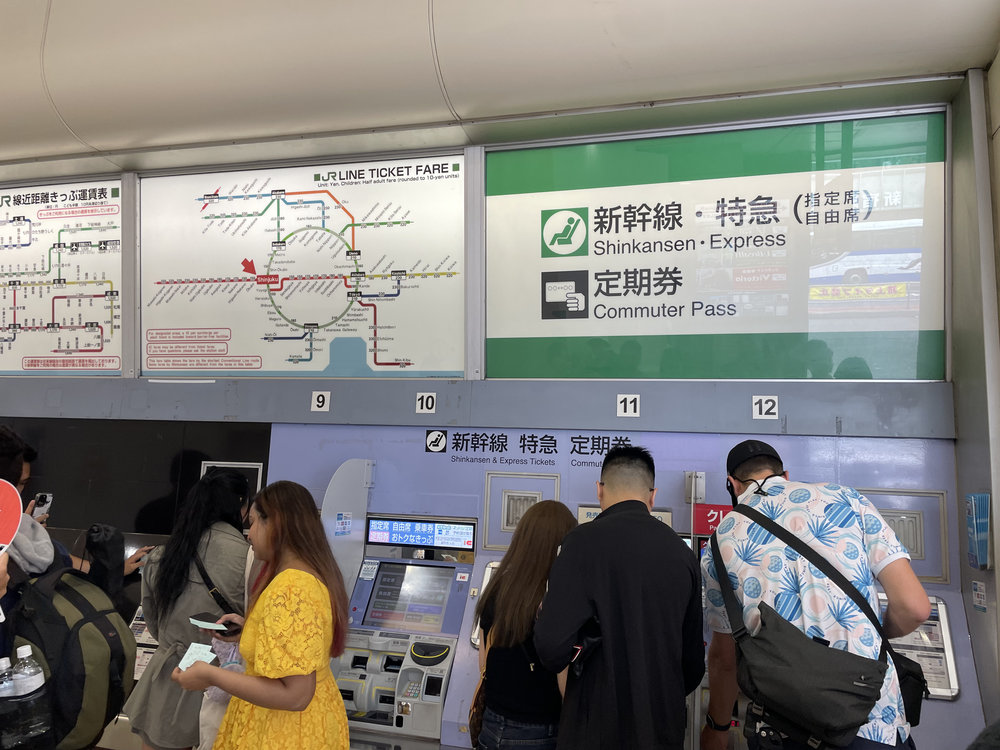 people booking their train tickets via ticketing machines