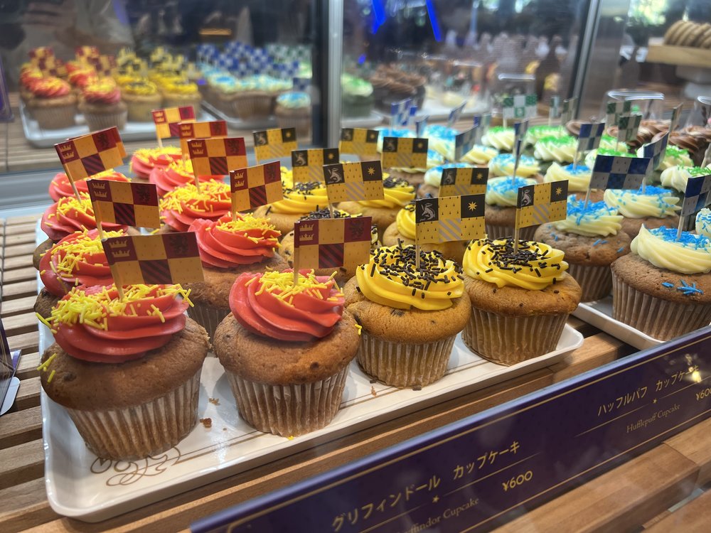 Gryffindor and Hufflepuff themed cupcakes with red and yellow icing on display