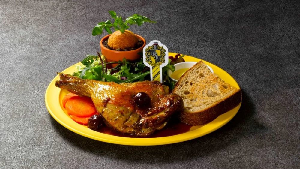 roast chicken, bread, carrots, and vegetables on a yellow plate