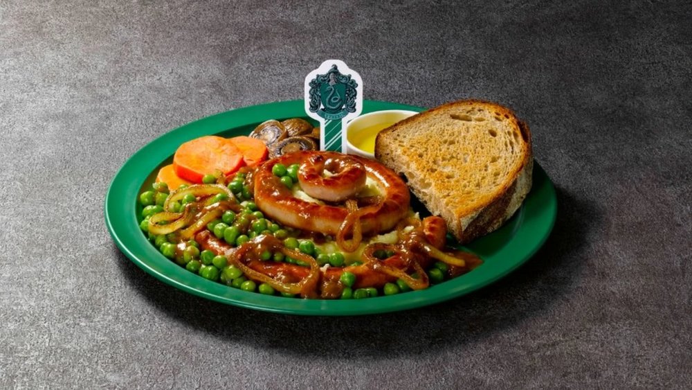 bangers and mash, bread, and vegetables on a green plate