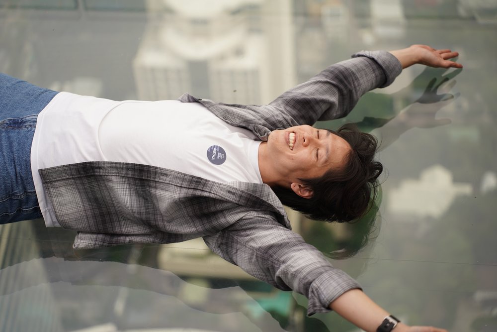 Man happily lying on the glass floor