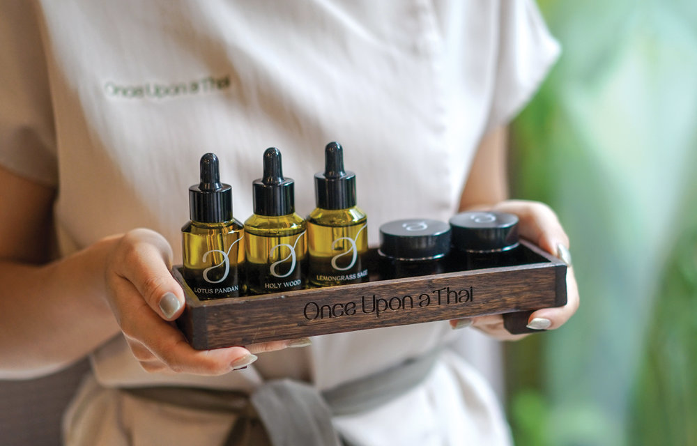 spa staff carrying a tray of various oils