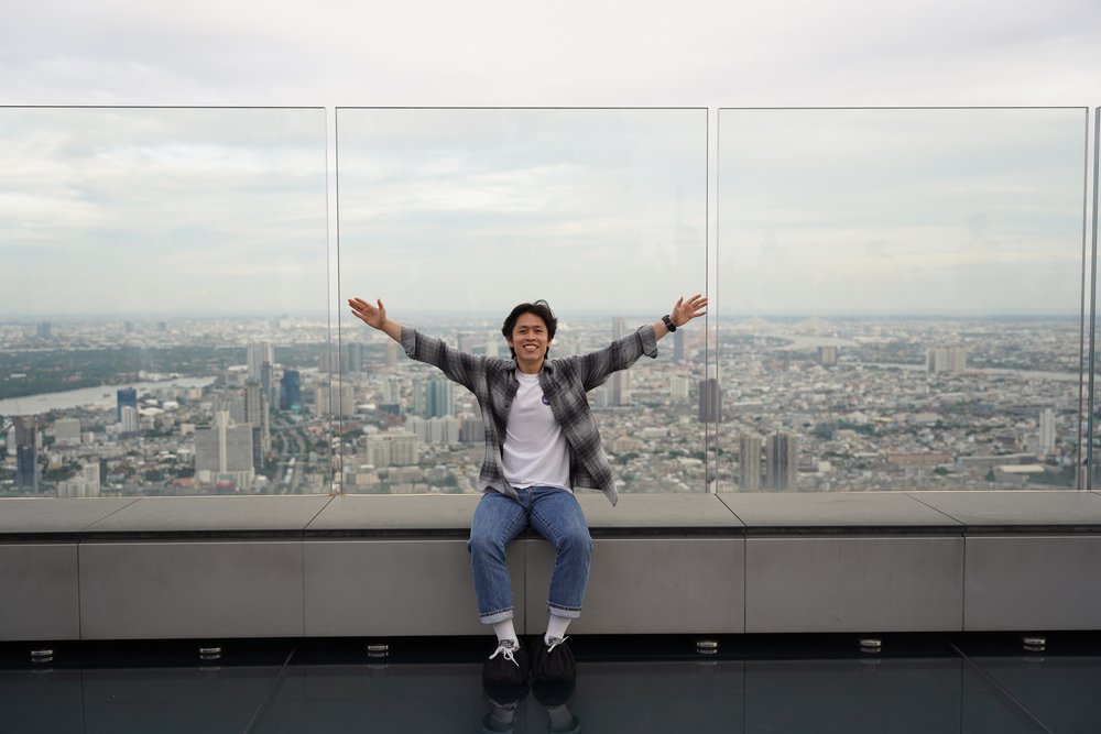 Man sitting on a couch surrounded by city views