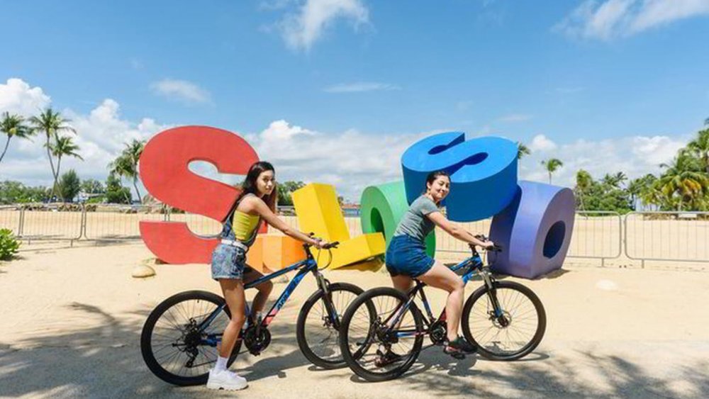 Cycling a bike looking for a perfect photo spot at Siloso Beach. Image credits to Klook