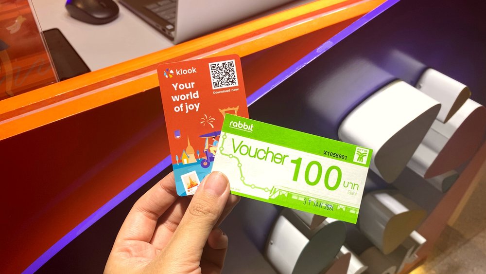 Person holding train card and cash voucher