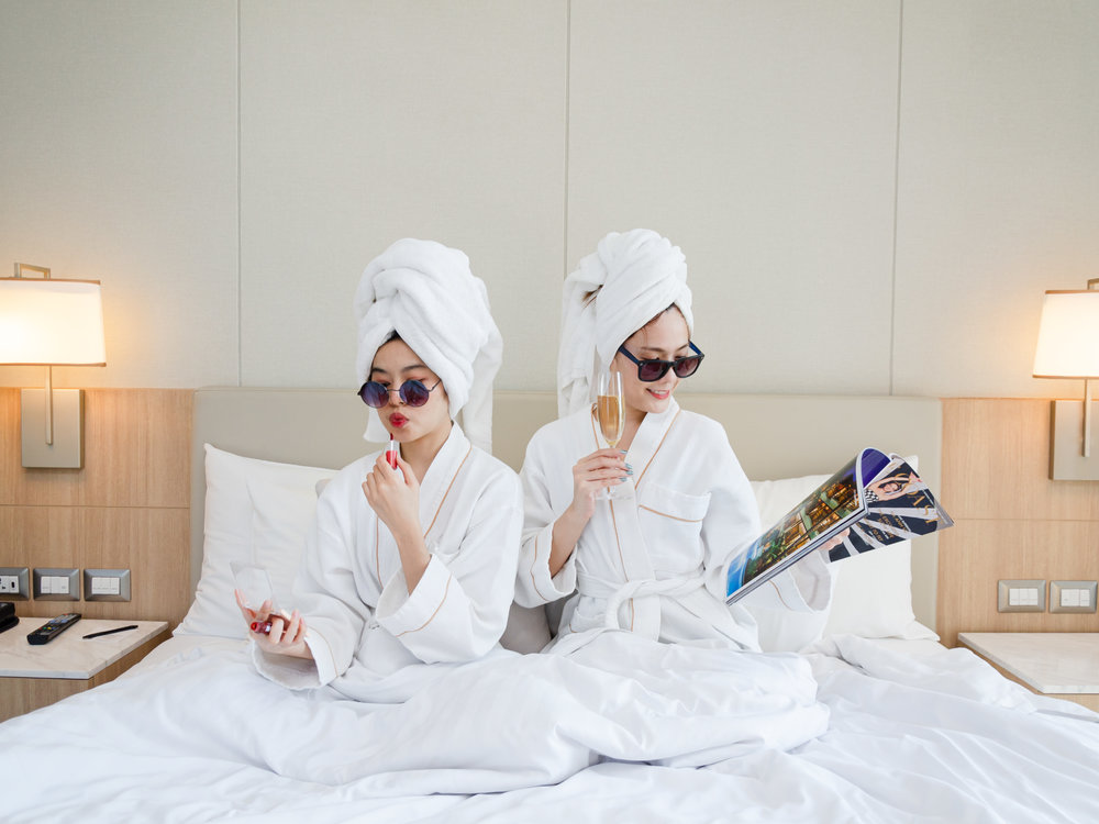 Two ladies in robes on a bed