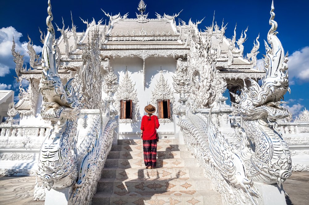 Woman in red standing in front of a white temple