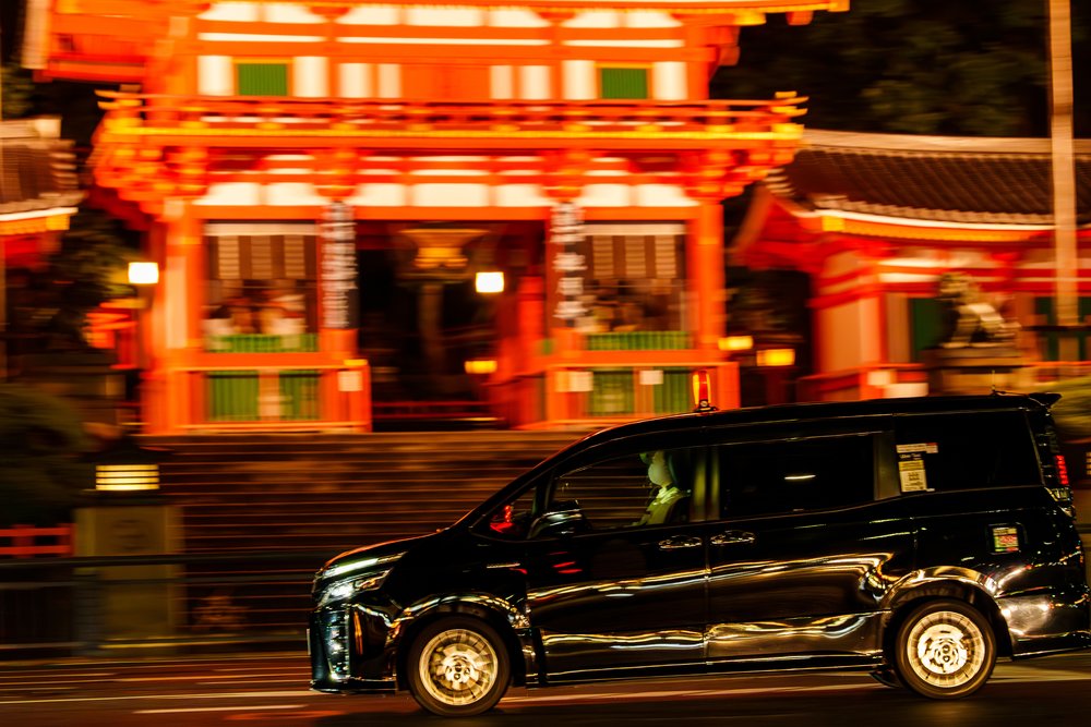 a taxi driving through kyoto at night