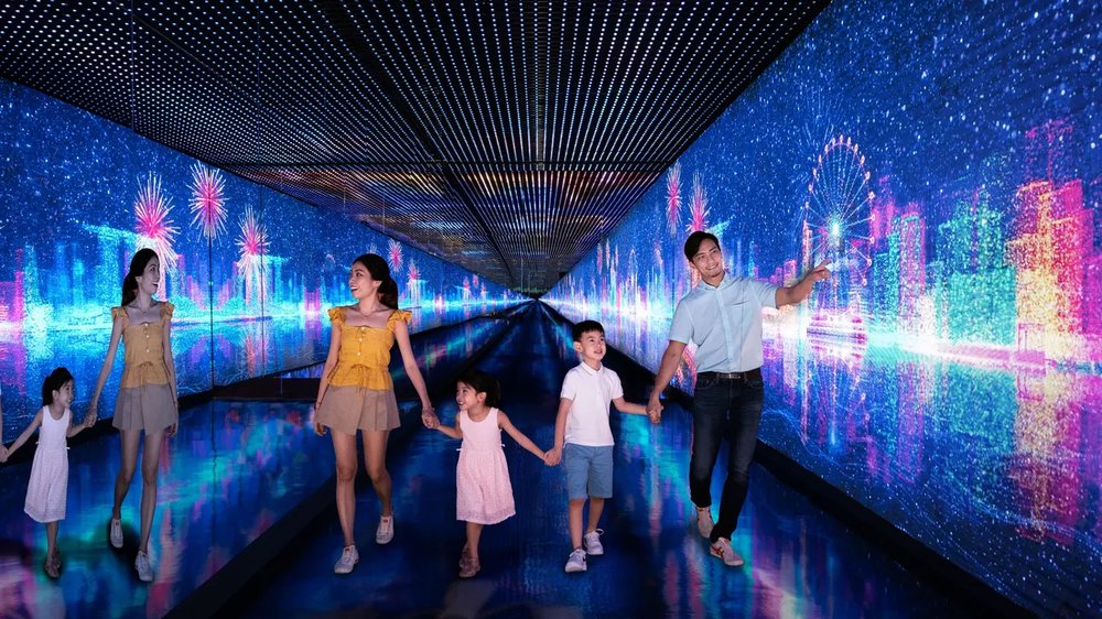 Family walks along corridor with illuminations on the walls