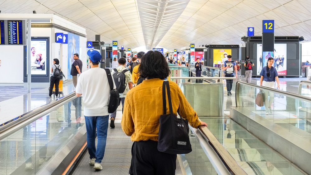 Lady in yellow on a moving walkway at the airport